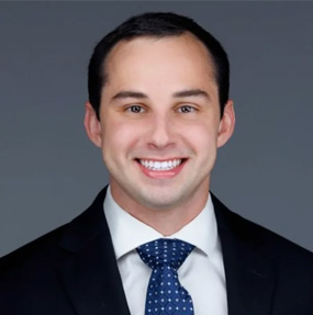 The image shows two different photographs of a man wearing a suit and tie, with a smiling expression in both instances.